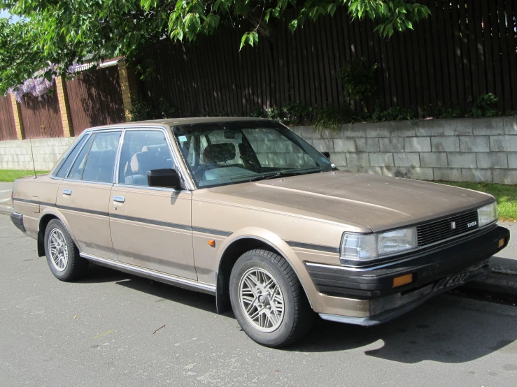 the beige car is parked on the street