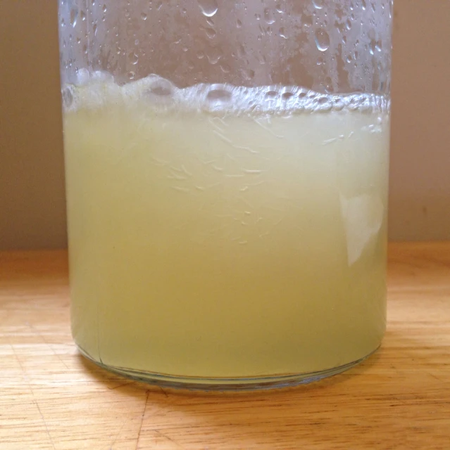 a glass with a liquid inside of it on a table