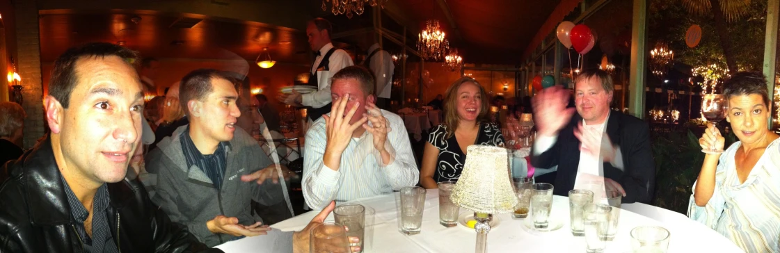 a group of people sitting around a white table