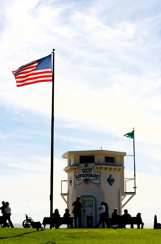 people sitting around in benches by a lifeguard tower