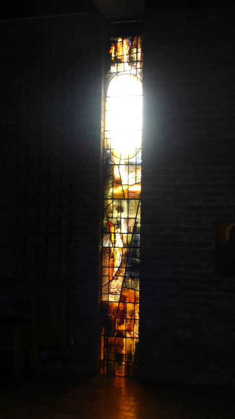 a church with dark lighting shining from the stained glass window