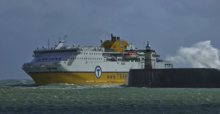 a yellow and white boat on the water with waves