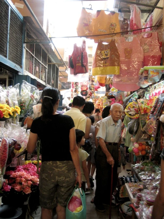 people walking around in a market area and looking at things