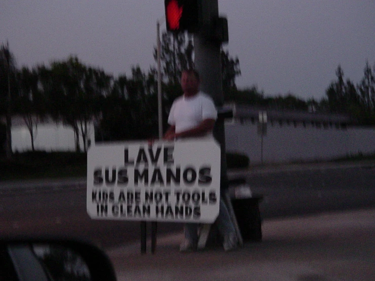 a man walking past a traffic light holding up a sign