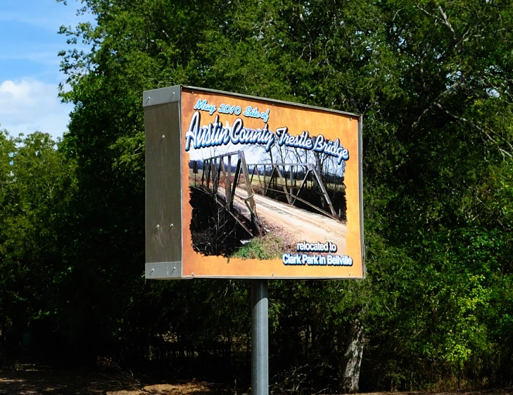 billboard sign displaying images and slogans beside street