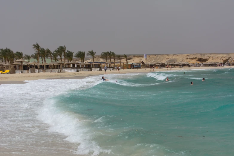 many people are enjoying swimming and surfing in the ocean