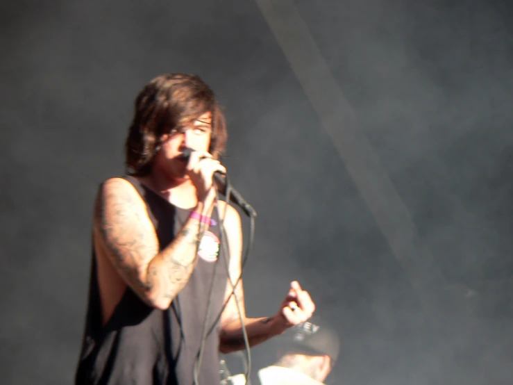 a male in a black tank top is holding a microphone