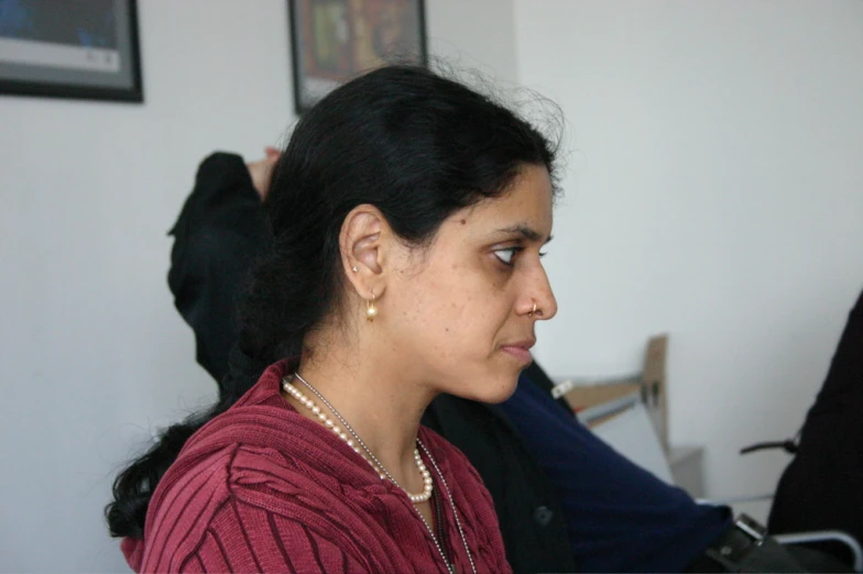 a woman in a red shirt stares ahead