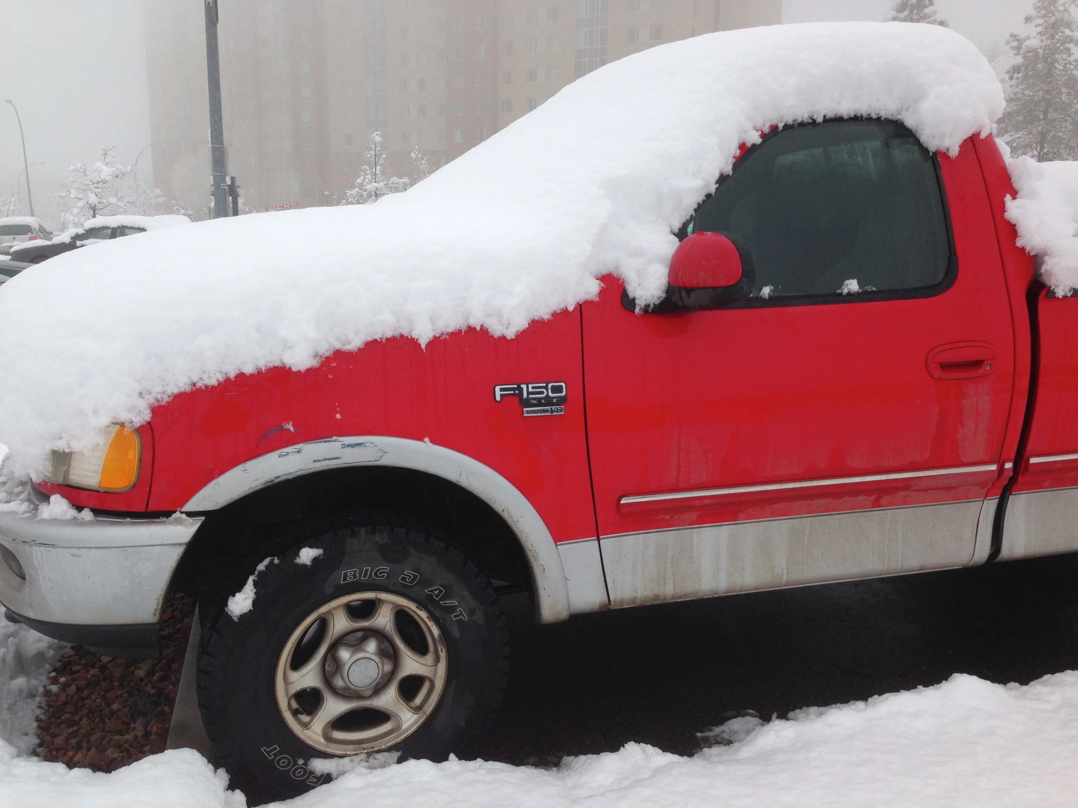 there is a truck covered in snow on the street