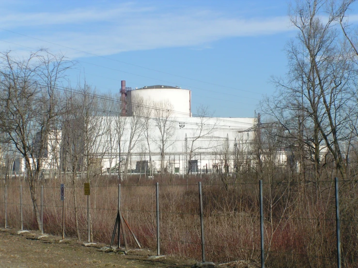 a factory behind a fenced in area on a clear day