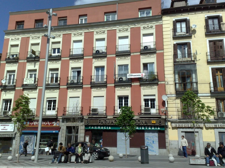 people are walking around in front of a red building