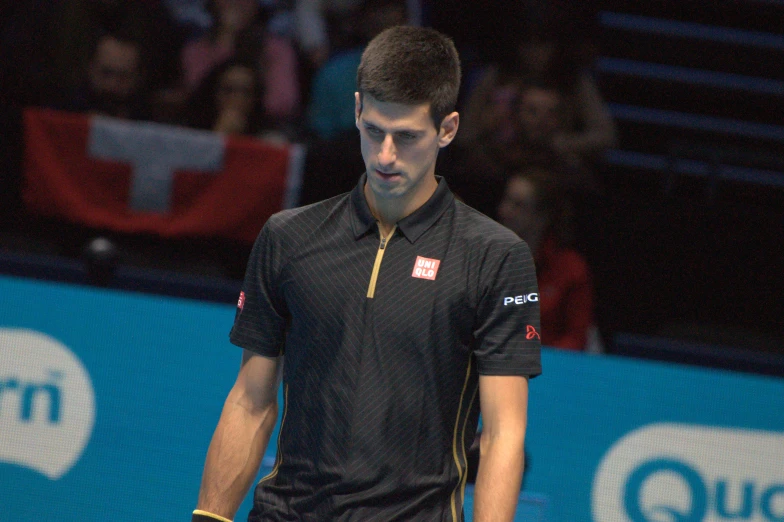 tennis player walking on court with ball in hand