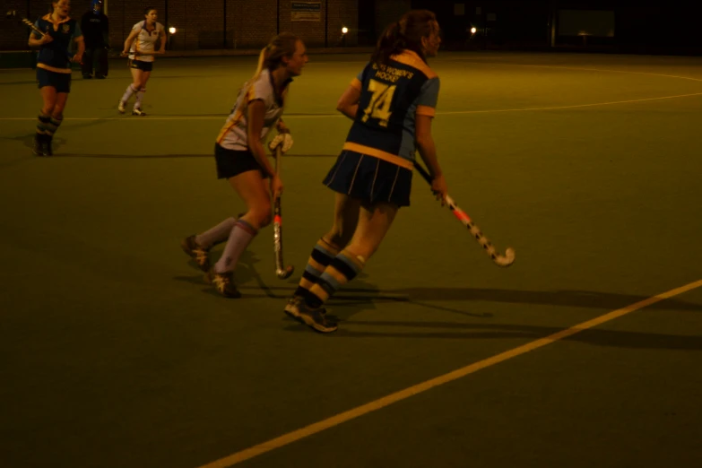 some girls in uniforms playing hockey on a field