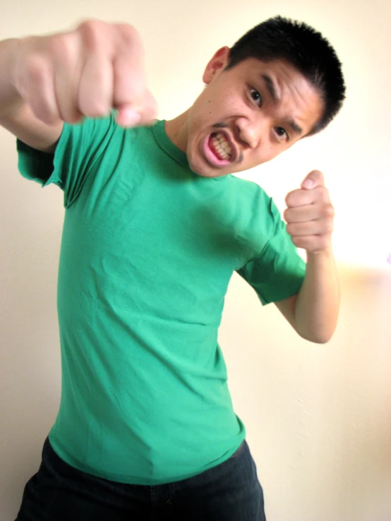 man in green shirt pointing a finger at the camera