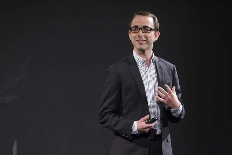 a man in a suit speaking into microphone