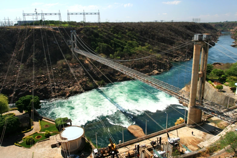 a river flows under a suspension bridge