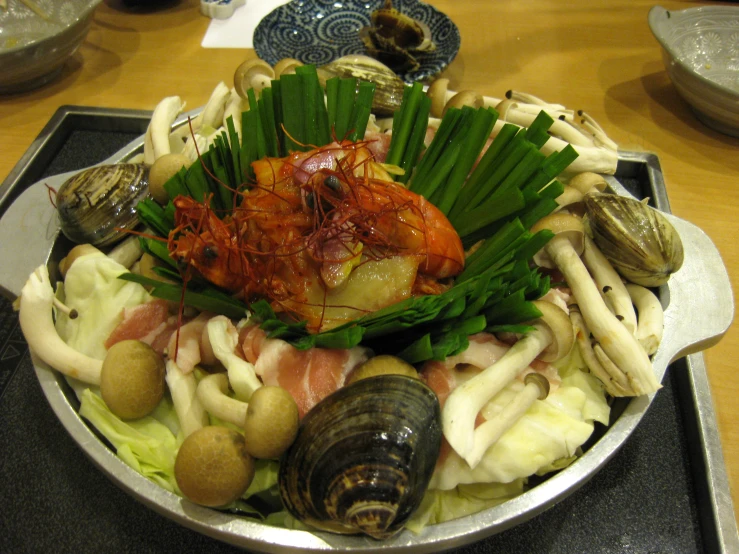 a platter filled with food covered in shells and vegetables