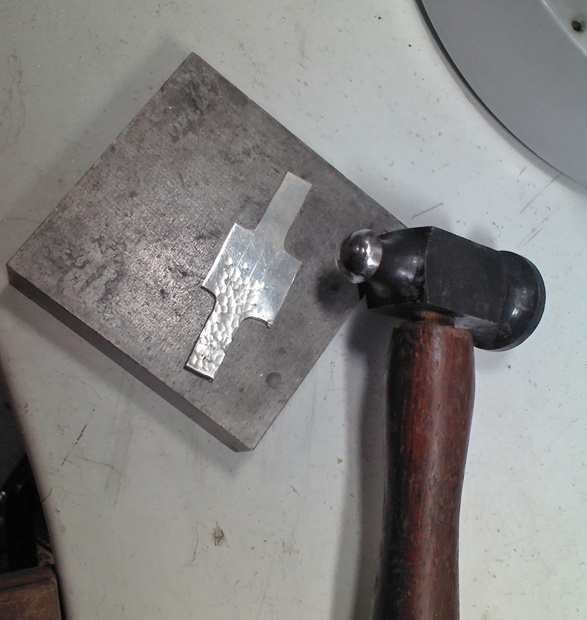 hammer and metal object on table with work tools