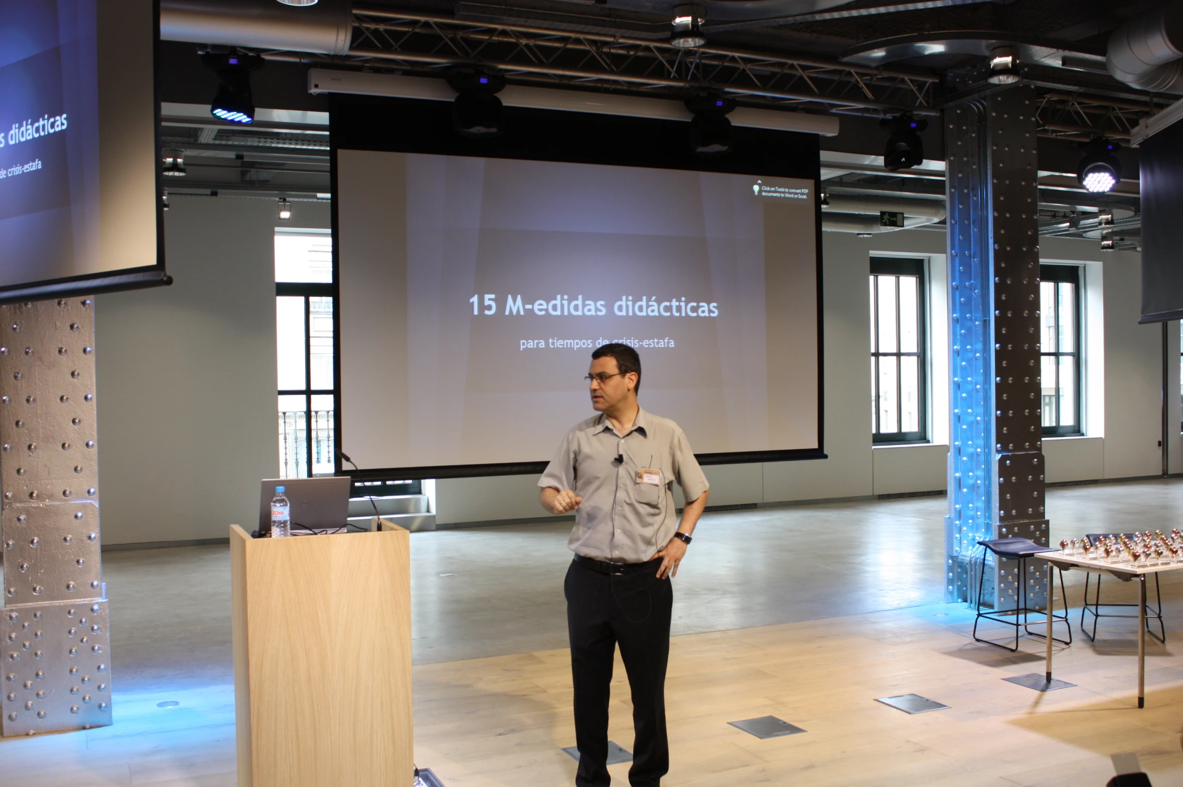 a man standing on a stage in front of a projection screen