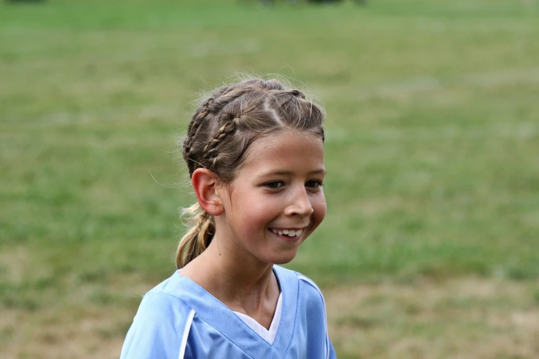 the girl is smiling while she has her hair in a ponytail