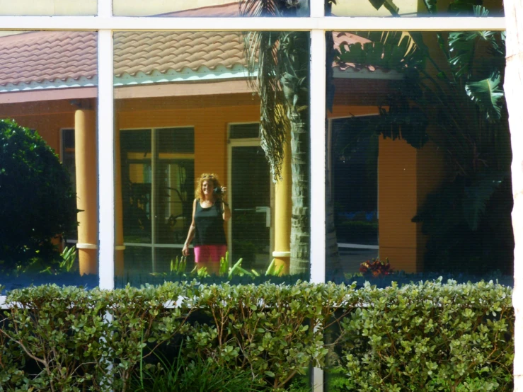 a woman standing next to a tree and a building