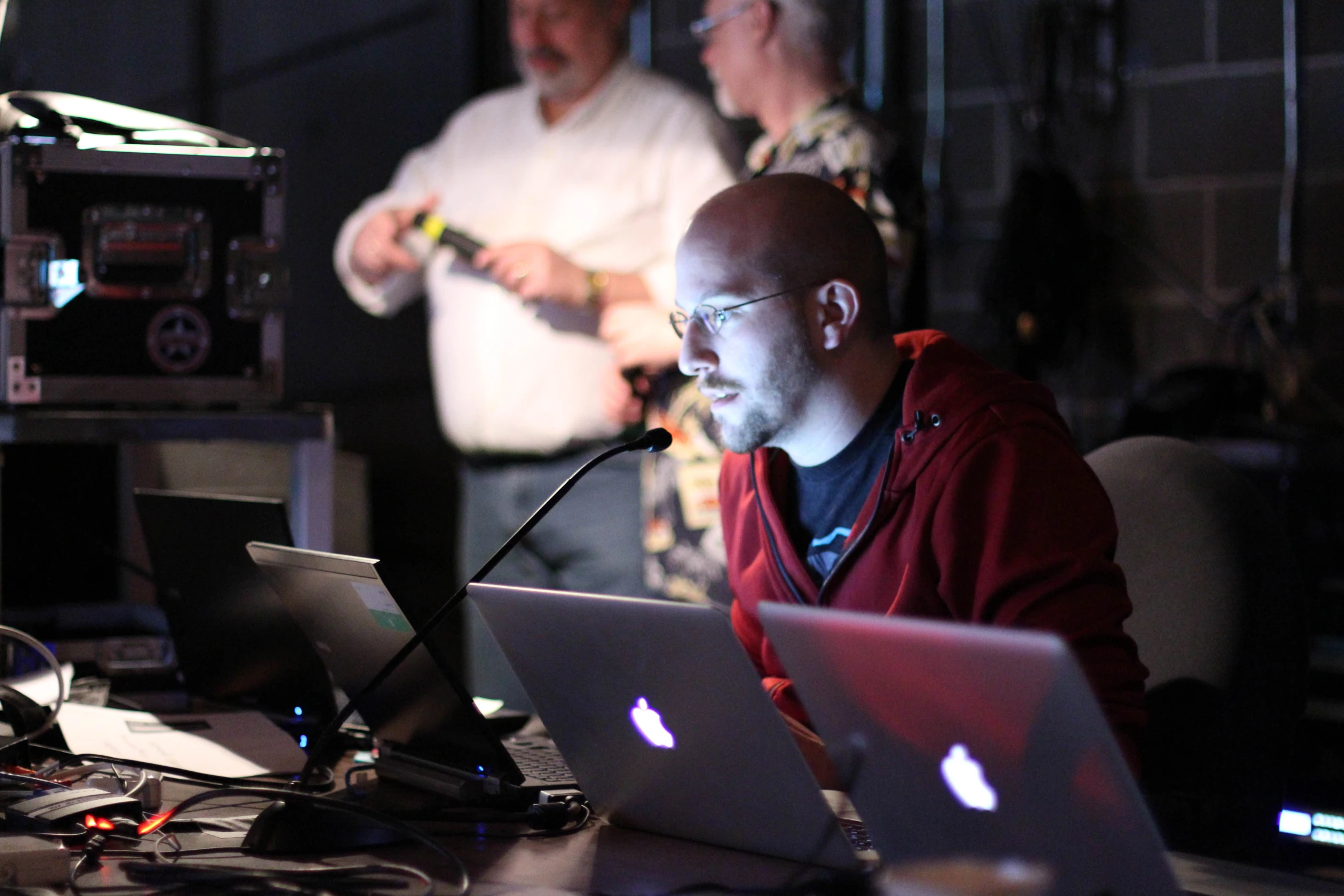 two men at computers talking in the background, on the other side