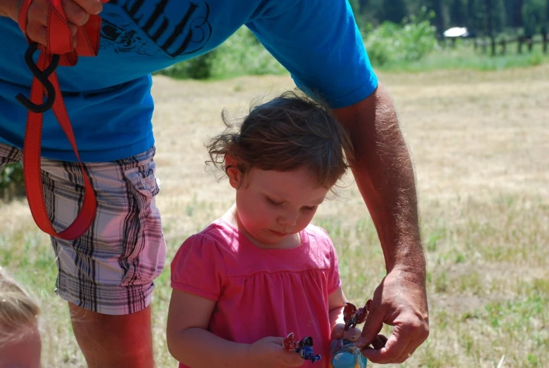 a girl holding a small flower in her hands