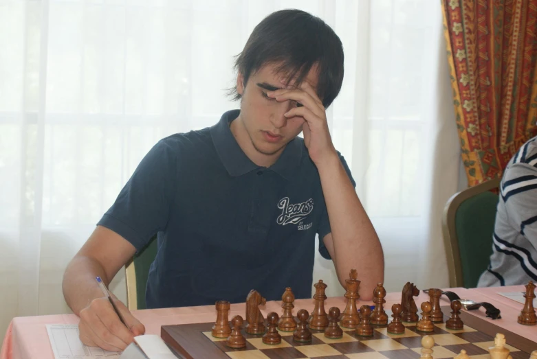 young man is playing chess, thinking of solution