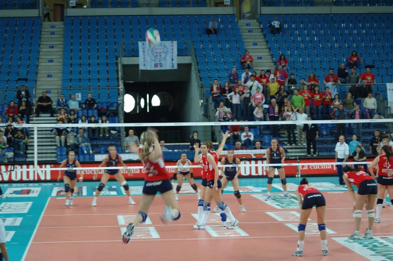 a group of women playing volleyball in a stadium