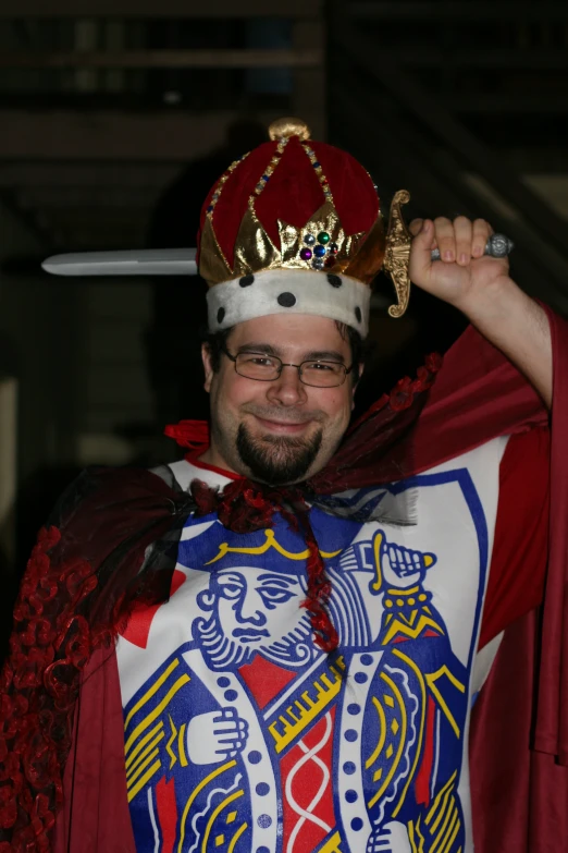 a man in a crown on his head holds a sword