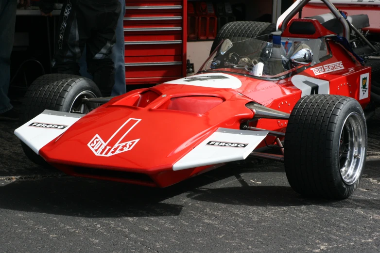 red racing car sitting in the parking lot