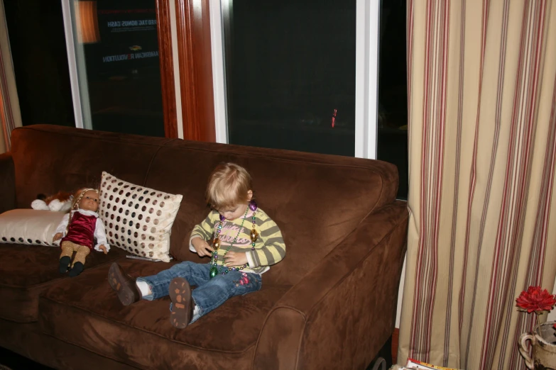 the little boy is sitting in the chair with stuffed animals