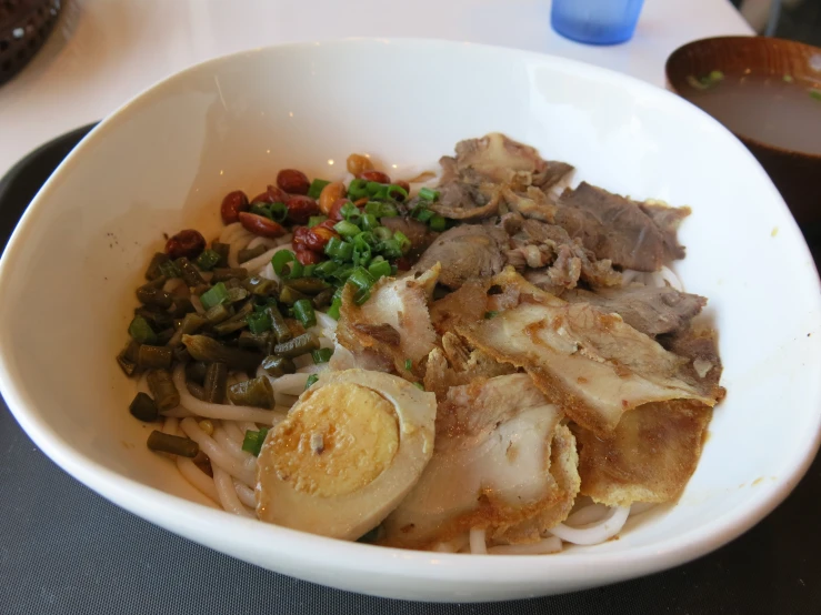 a bowl of food with onions and meat in it