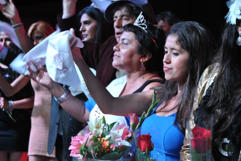 a group of people are holding flowers and hats