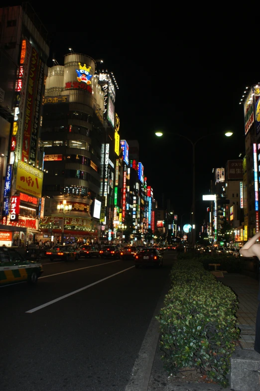 a woman standing on the sidewalk in a busy street