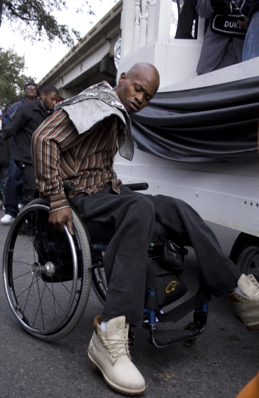 a man in a wheelchair with his foot on a luggage cart