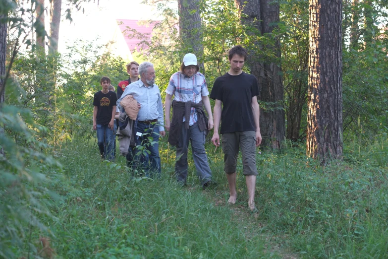 a group of men walking down a forest path