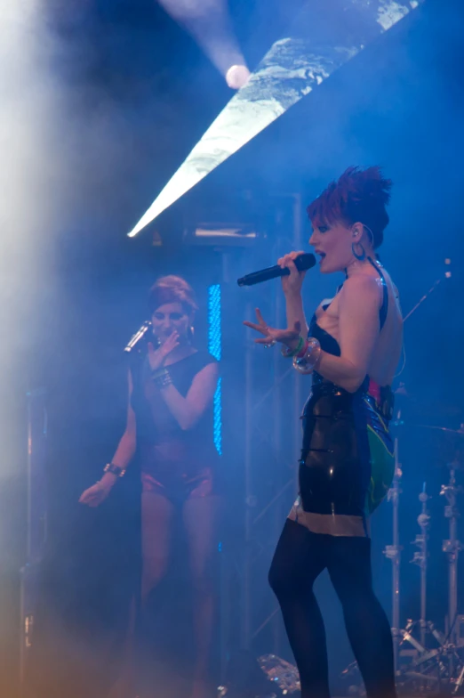 a girl with short skirt singing at a concert