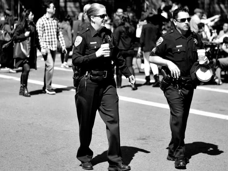 two police officers are walking down the street