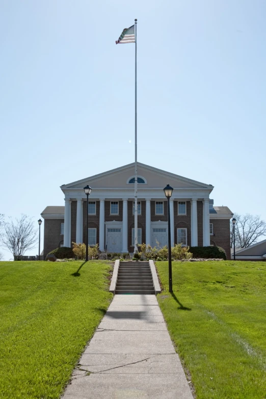 there is a large white building with a flag in front