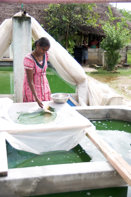 a woman that is standing in a water area with food