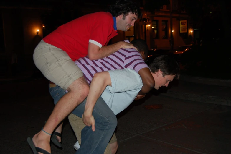 a guy is upside down on another guy's skateboard