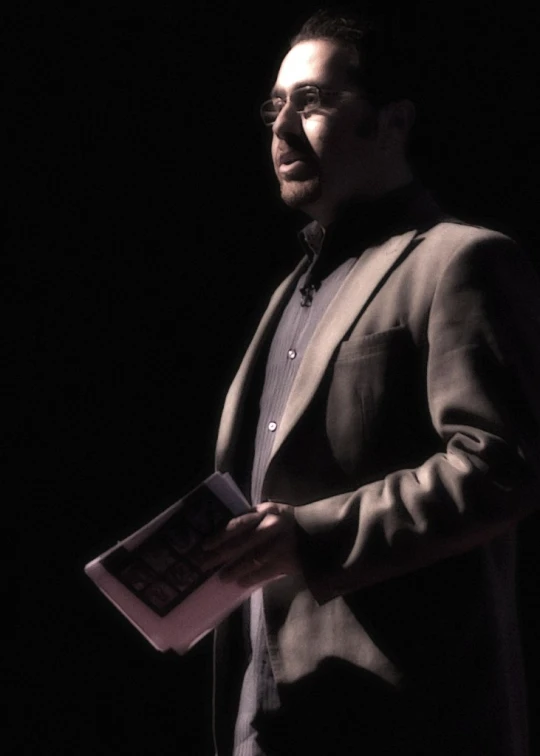 a man in glasses is reading the text on a book