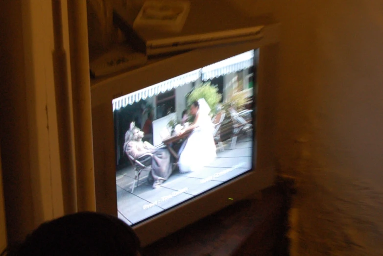 someone looking at the tv screen with their wedding picture on it