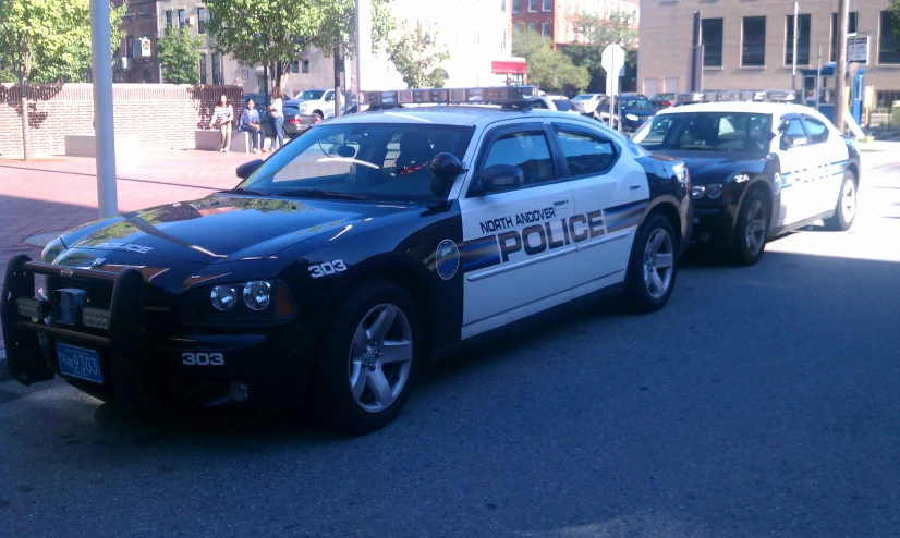 two police cars are parked on the side of a street