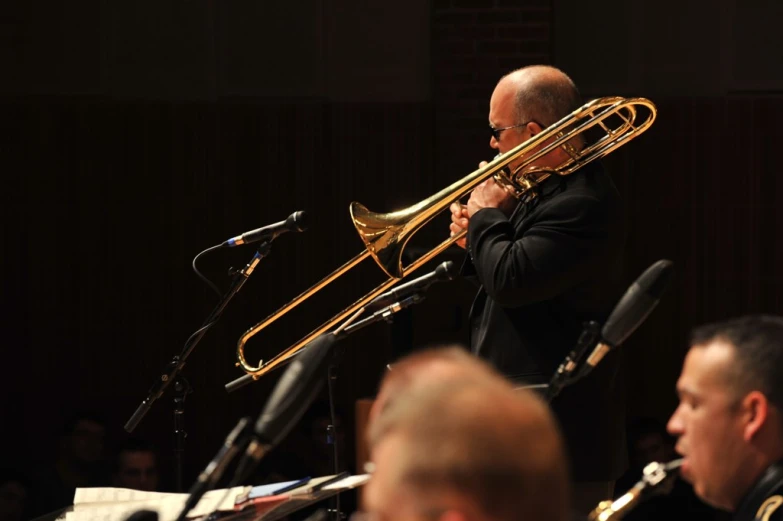 man in suit playing trumpet at a concert