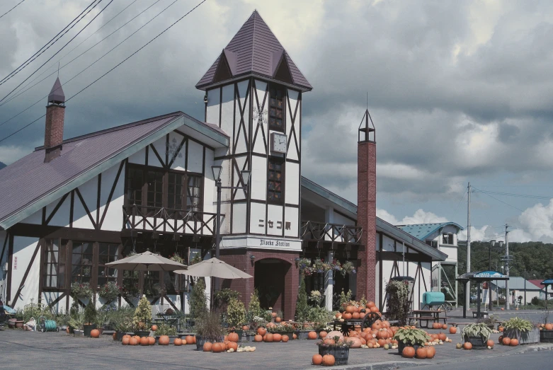 a brick and white building in the middle of some pumpkins