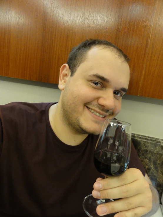 a man holding up a wine glass for the camera