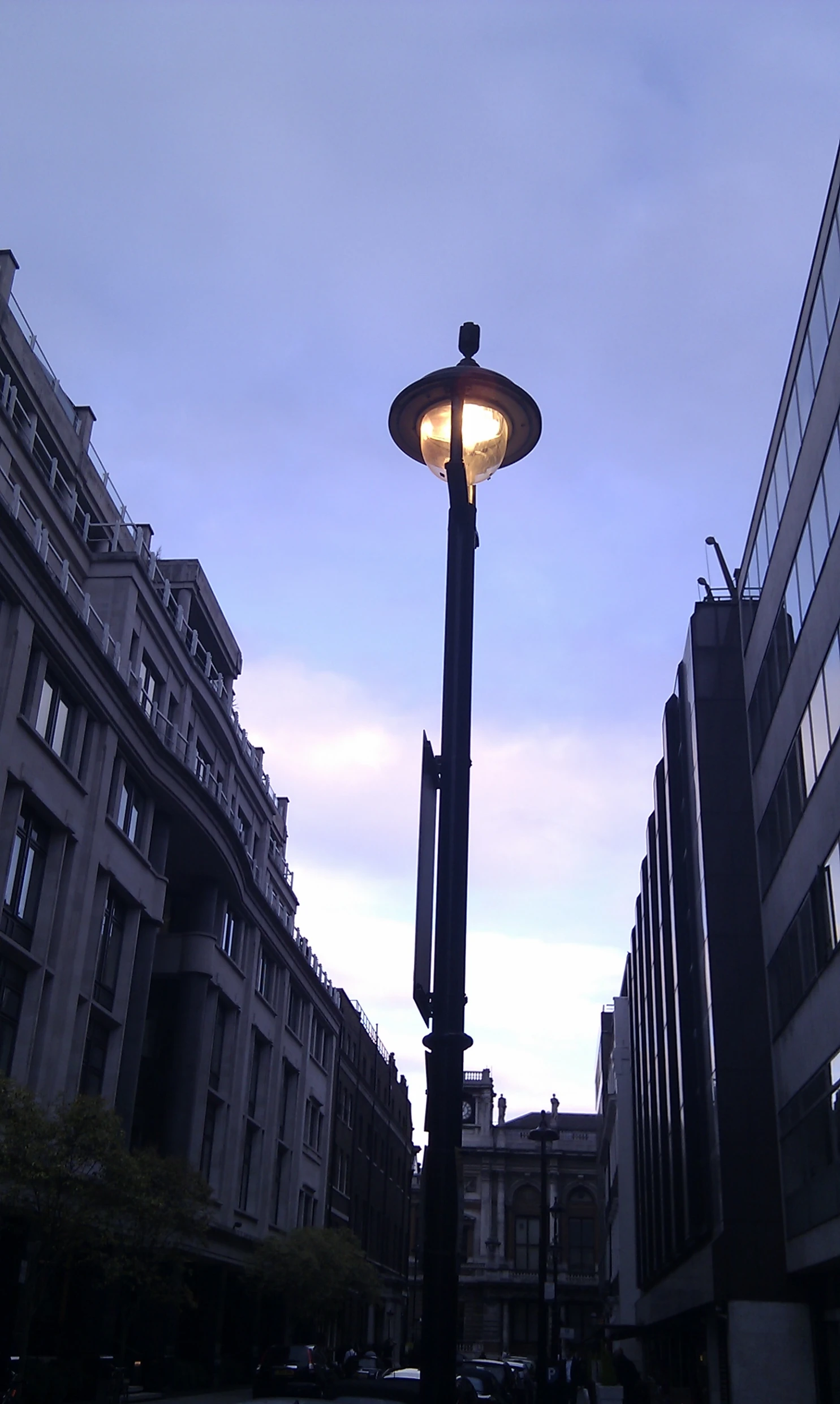 a lamp post lit up in the evening time