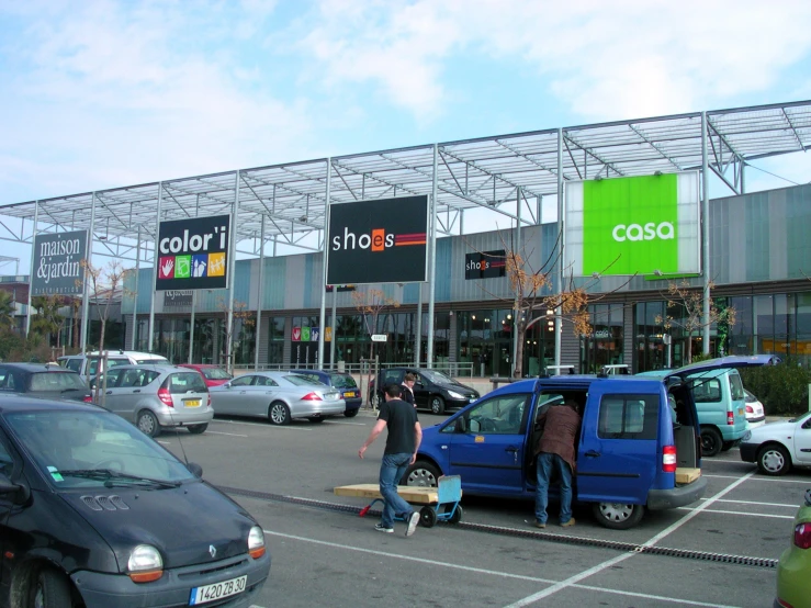 several cars are parked outside a shop with signs and signs above